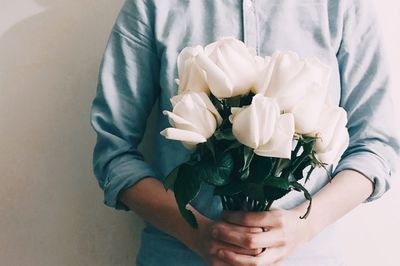 Midsection of man holding bouquet