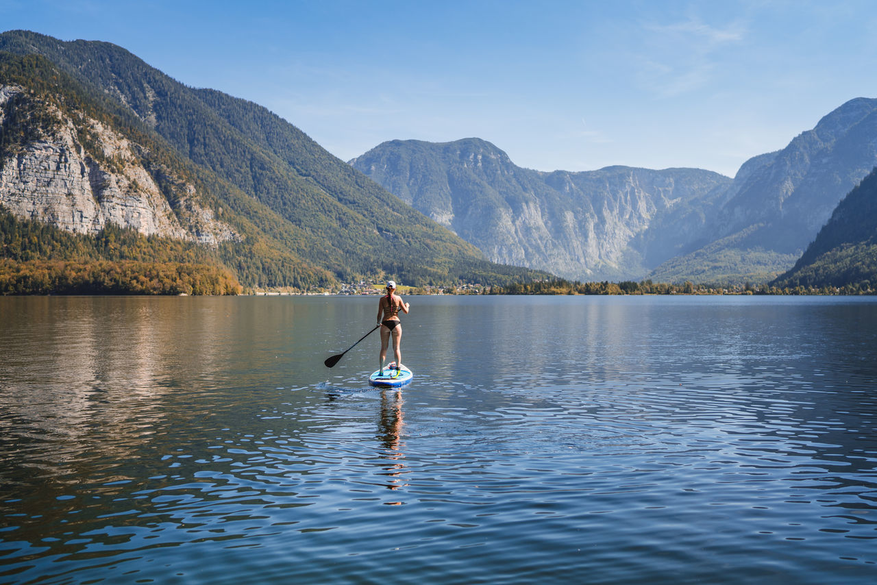 water, mountain, beauty in nature, one person, lake, scenics - nature, real people, waterfront, tranquil scene, lifestyles, leisure activity, sky, mountain range, tranquility, day, nature, non-urban scene, oar, nautical vessel, outdoors