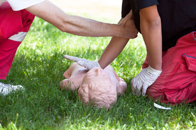 Low section of people lying on grass