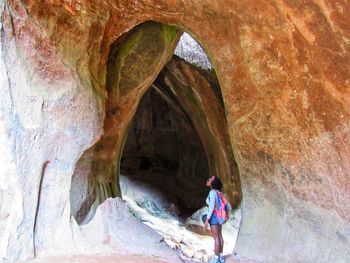 Rear view of woman in cave