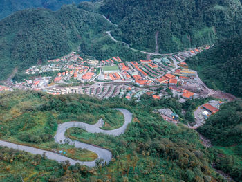 High angle view of winding road amidst trees in forest