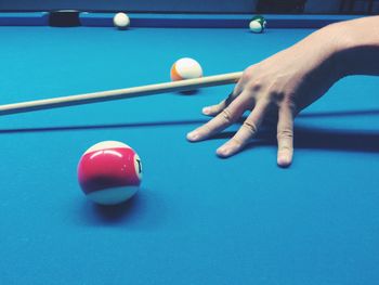 Cropped hand of man playing pool