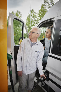 Senior couple refueling van