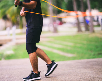 Blurry photo of man using jumping rope outdoors. copy space.