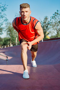 Portrait of young man exercising on road