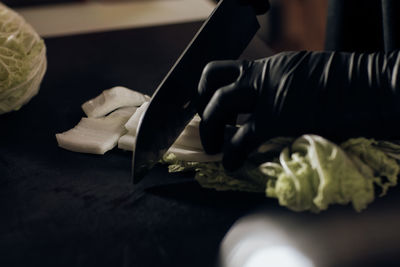 High angle view of person cutting meat on table