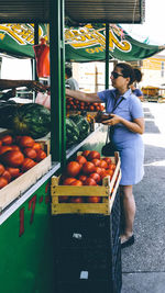 Full length of woman buying food at market stall