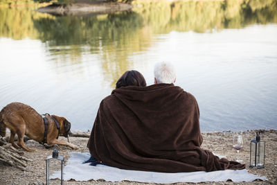 Relaxed senior couple with dog at a lake