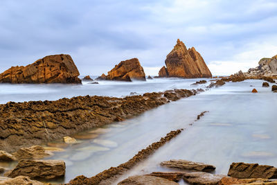 Panoramic view of rocks on beach against sky