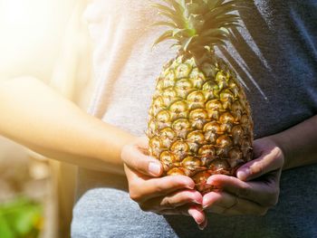 Midsection of woman holding fruit