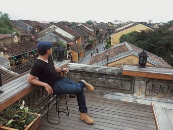 Full length of woman sitting on steps against sky