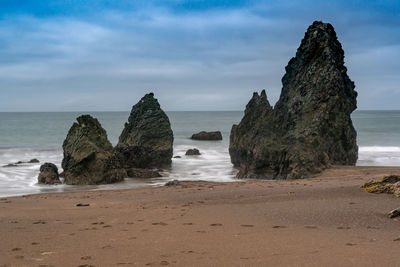 Rocks on beach against sky