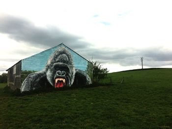 Building on field against sky