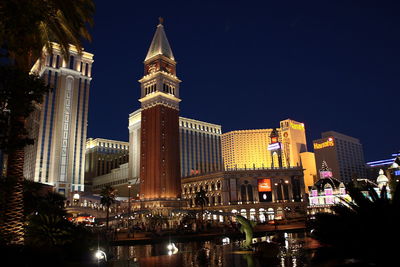 Illuminated buildings against sky at night