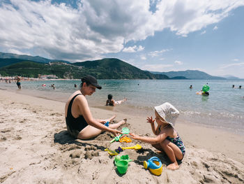 People at beach against sky