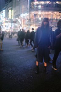 Rear view of man and woman walking in illuminated building