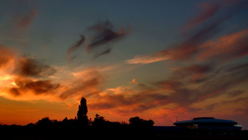 Low angle view of silhouette trees against dramatic sky