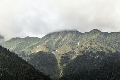 Scenic view of mountains against cloudy sky