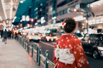 Woman standing on street in city at night