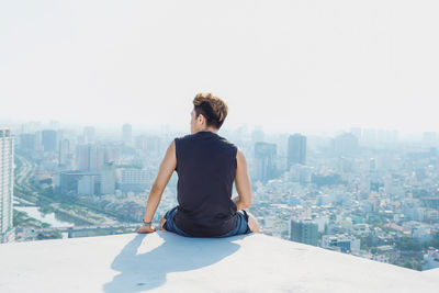 Man looking at city buildings against clear sky