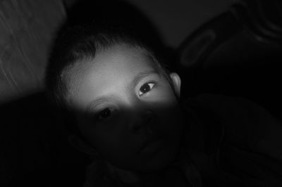 High angle portrait of boy in dark at home