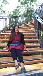 Full length of woman sitting on staircase