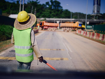 Rear view of woman walking on road