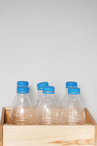 Close-up of bottles on table against wall