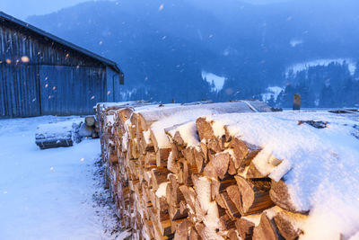 Wooden logs on snow covered field