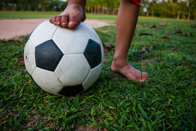 Low section of child playing soccer on grass