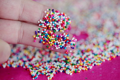 Close-up of hand holding multi colored candies