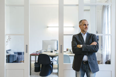 Businessman standing in office looking sideways