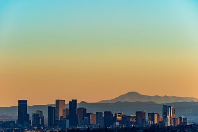 Buildings against clear sky at sunset