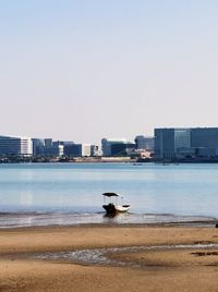 Boats in sea against clear sky