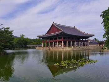 Building by lake against sky