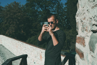 Young man photographing with mobile phone