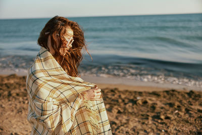 Rear view of woman standing at beach