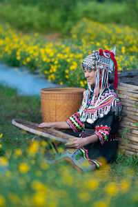 Woman sitting on yellow flower in field