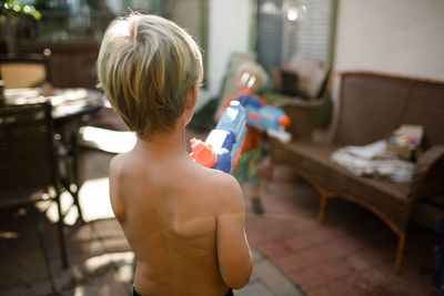 Rear view of shirtless boy at home