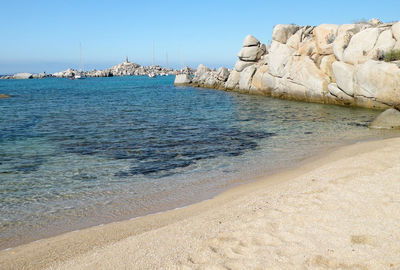 Rocks on beach against clear sky