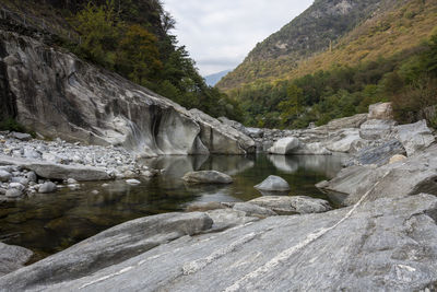 Scenic view of waterfall by mountains against sky