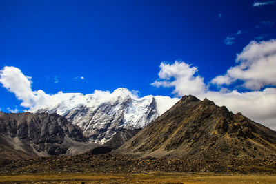 Scenic view of snowcapped mountains against blue sky