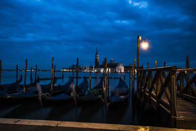 Boats moored in canal at dusk