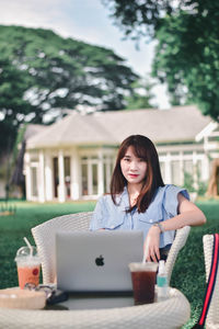 Portrait of young woman sitting at table
