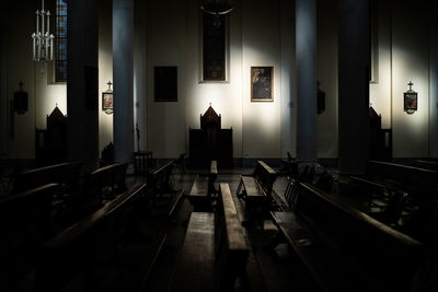 Empty chairs and tables in illuminated building