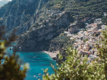 High angle view of sea by mountain against sky