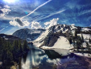 Scenic view of lake and snow covered mountains against sky