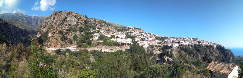 Panoramic view of mountains against blue sky