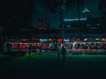 People in illuminated city at night