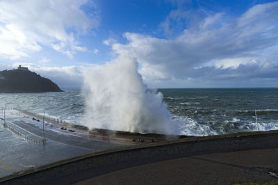 Waves splashing on sea against sky